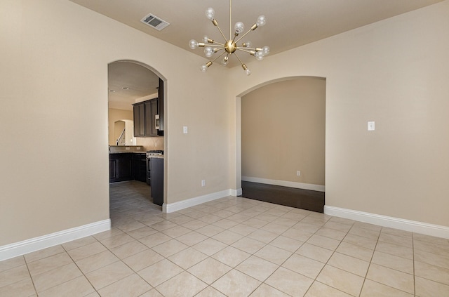 unfurnished room featuring light tile patterned flooring and a chandelier