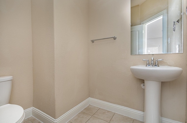 bathroom with tile patterned flooring, sink, and toilet