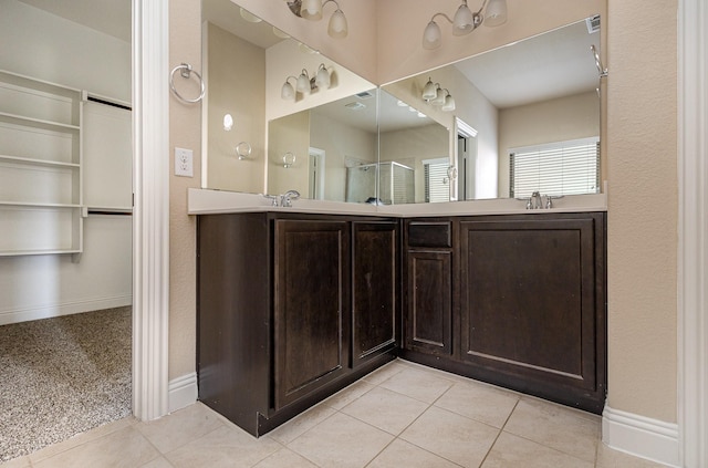 bathroom featuring tile patterned flooring, vanity, and walk in shower