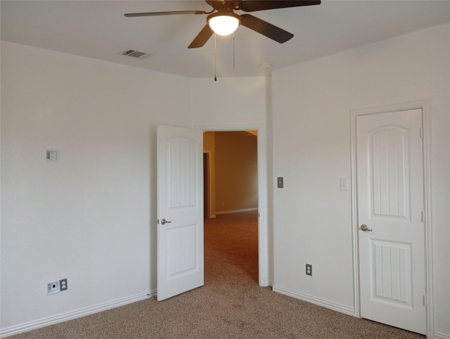 spare room featuring ceiling fan and light colored carpet