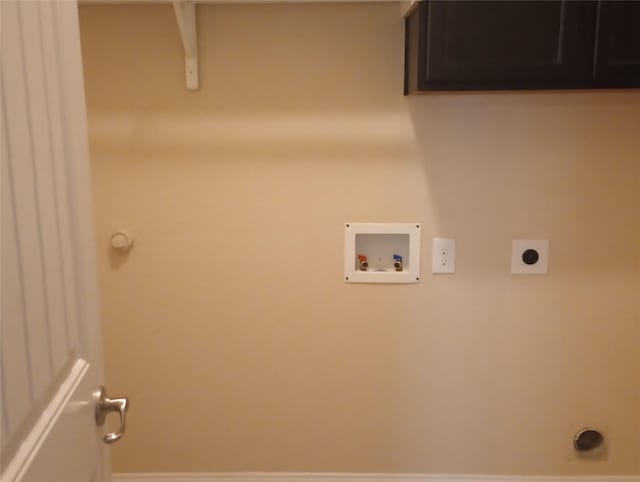 washroom with hookup for an electric dryer, hookup for a washing machine, and cabinets