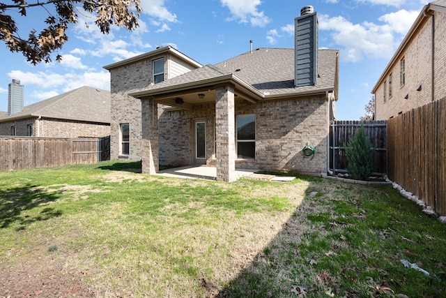 back of house with a yard and a patio