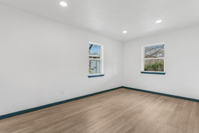 empty room with light hardwood / wood-style floors and a wealth of natural light