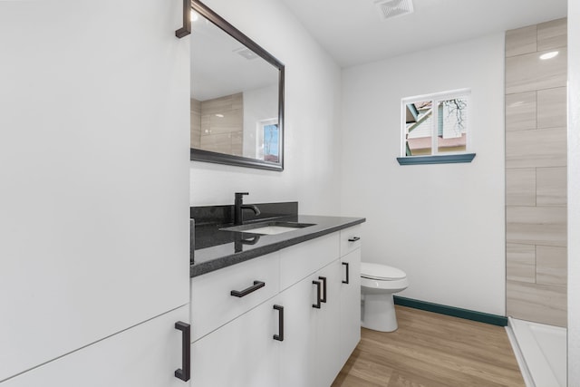 bathroom with hardwood / wood-style flooring, vanity, and toilet