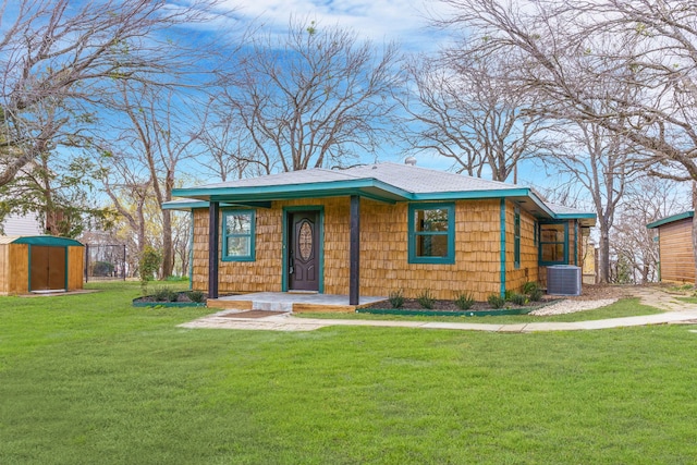 view of front of home featuring cooling unit and a front yard