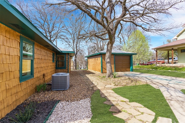 view of yard with a garage, an outbuilding, and cooling unit