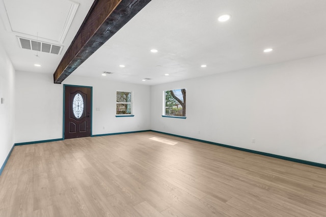 entryway with beam ceiling and light wood-type flooring