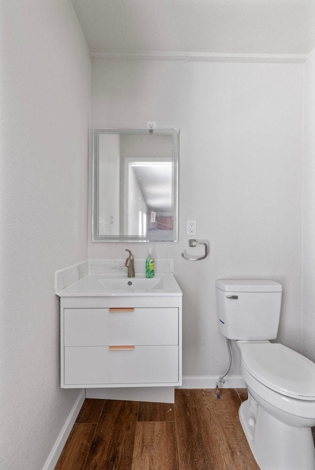 bathroom with toilet, hardwood / wood-style flooring, and vanity