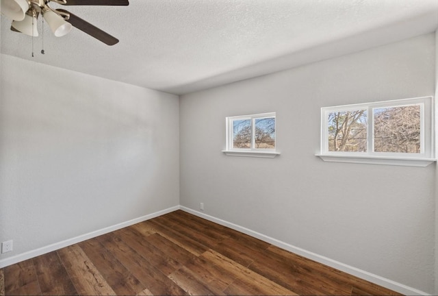 spare room featuring a textured ceiling, dark wood-type flooring, and ceiling fan