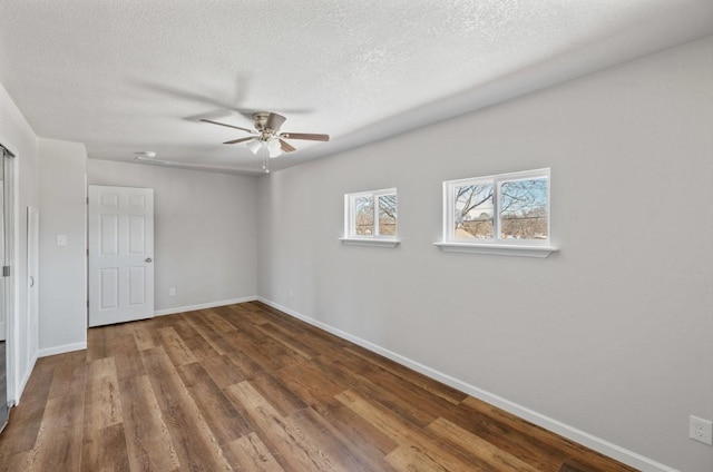 spare room featuring a textured ceiling, ceiling fan, and dark hardwood / wood-style flooring