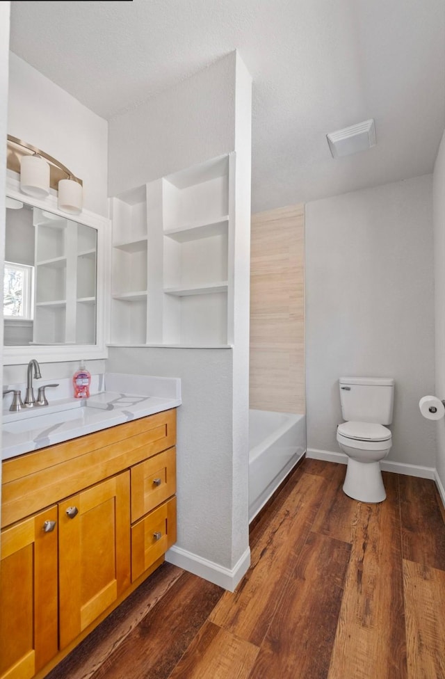 bathroom featuring toilet, vanity, and hardwood / wood-style floors