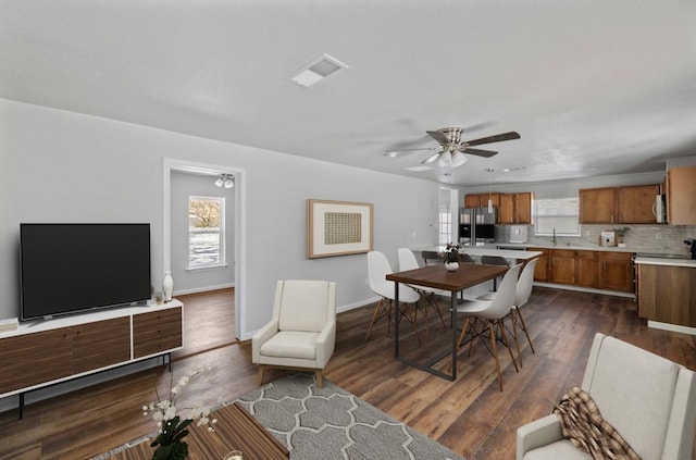 dining room with ceiling fan, dark wood-type flooring, and sink