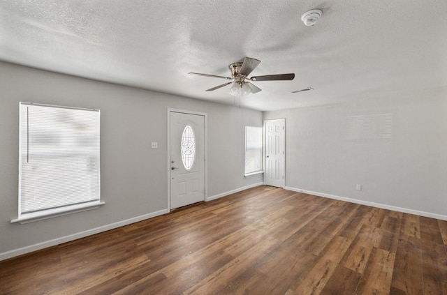 foyer featuring a textured ceiling, dark wood-type flooring, and ceiling fan