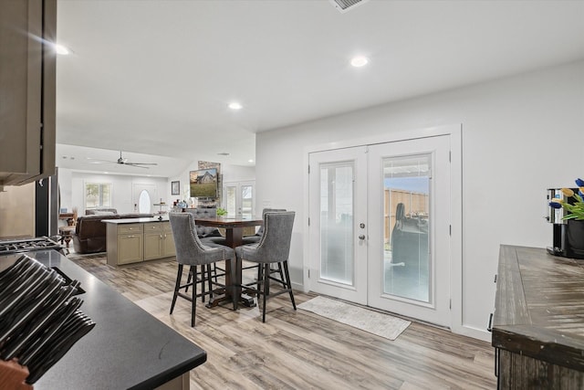 dining area featuring ceiling fan, lofted ceiling, light hardwood / wood-style flooring, and french doors