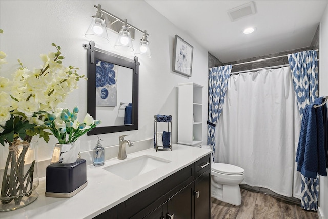 bathroom featuring toilet, vanity, a shower with shower curtain, and hardwood / wood-style floors