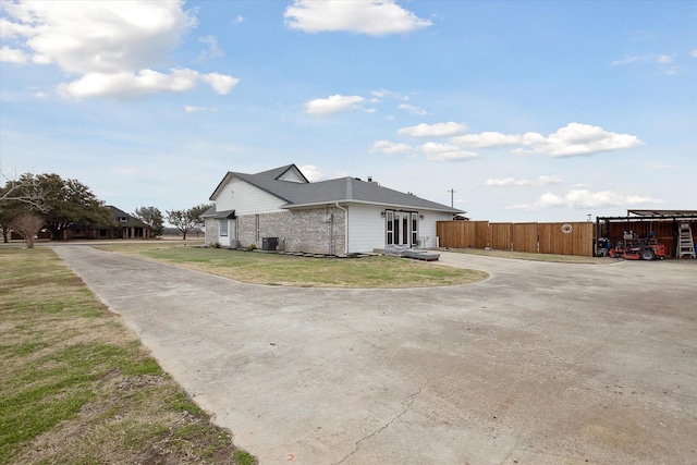 view of home's exterior with a lawn and central AC