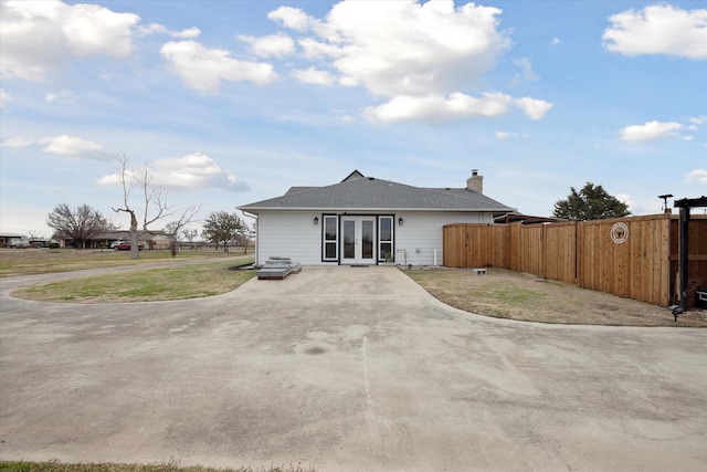 rear view of house with a lawn and french doors