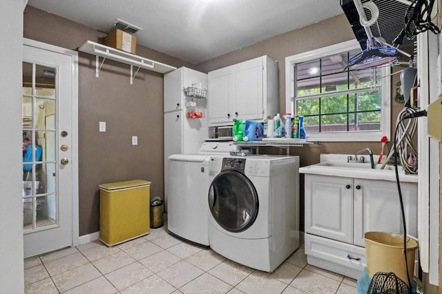 laundry area featuring cabinets, sink, washer and dryer, and light tile patterned floors