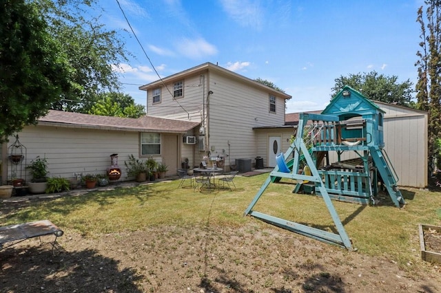 back of house featuring a yard, a playground, and central air condition unit