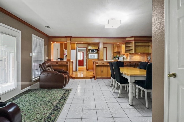 living room with light tile patterned flooring and ornamental molding