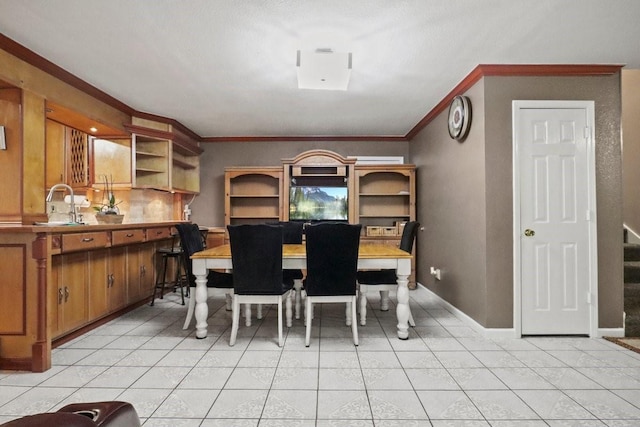 tiled dining area featuring ornamental molding and sink