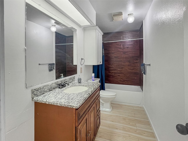 full bathroom featuring hardwood / wood-style floors, toilet, vanity, and shower / washtub combination