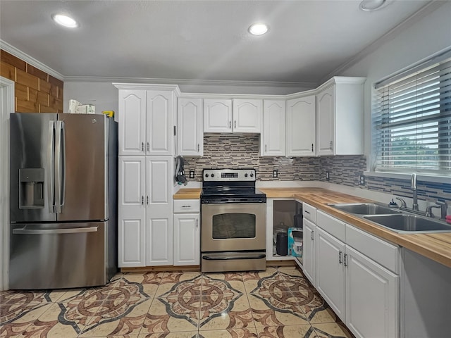 kitchen with wooden counters, white cabinetry, stainless steel appliances, sink, and ornamental molding