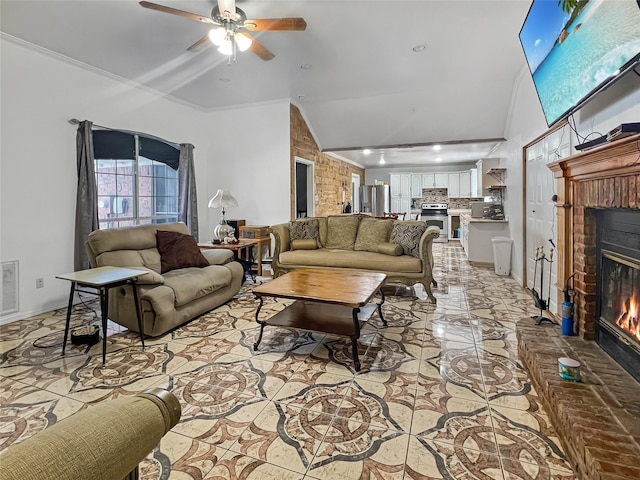 living room with ceiling fan, ornamental molding, lofted ceiling, and a fireplace