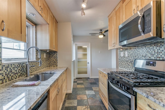 kitchen featuring tasteful backsplash, sink, light stone countertops, appliances with stainless steel finishes, and light brown cabinetry