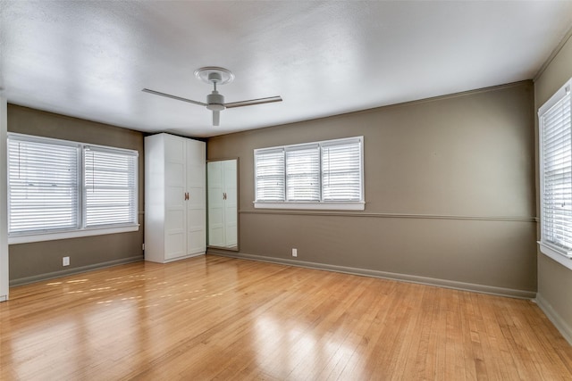 unfurnished bedroom with ceiling fan, multiple windows, and light hardwood / wood-style flooring