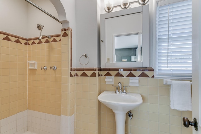 bathroom featuring sink and tile walls