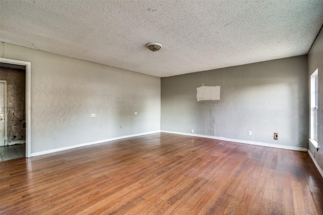 empty room featuring a textured ceiling and hardwood / wood-style flooring