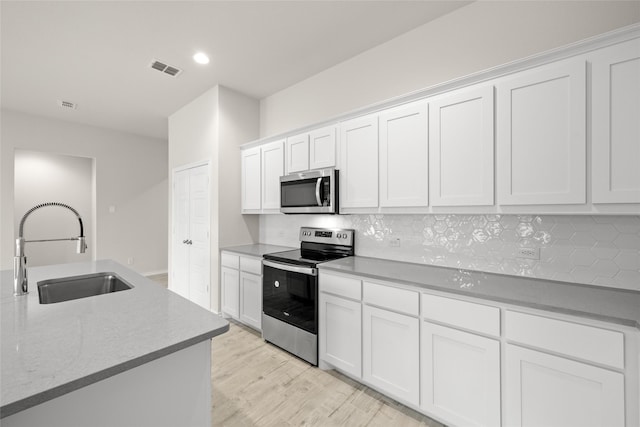 3656 N Crowley Cleburne Rd, Fort Worth, TX 76036 - kitchen with sink, white cabinets, backsplash, light hardwood / wood-style floors, and stainless steel appliances