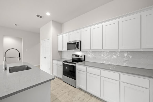 3656 N Crowley Cleburne Rd, Fort Worth, TX 76036 - kitchen featuring sink, white cabinets, backsplash, stainless steel appliances, and light wood-type flooring