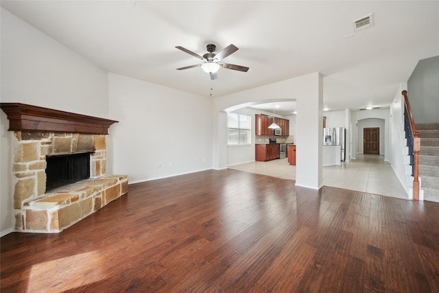 unfurnished living room with a fireplace, ceiling fan, and light hardwood / wood-style floors