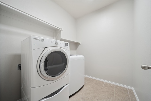 laundry room featuring light tile patterned flooring and washing machine and clothes dryer