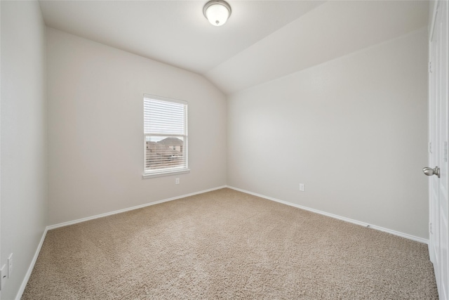 unfurnished room featuring carpet flooring and vaulted ceiling