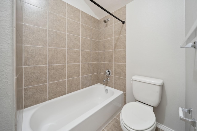 bathroom with toilet, vaulted ceiling, and tiled shower / bath combo