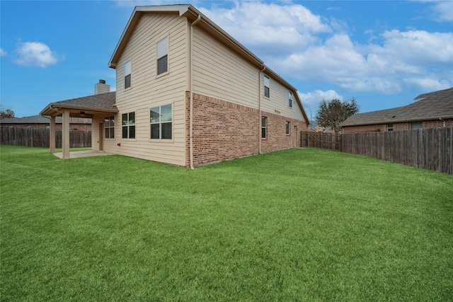 rear view of property with a lawn and a patio