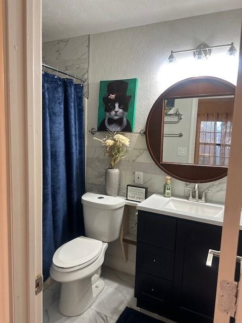 bathroom with vanity, a textured ceiling, decorative backsplash, and toilet