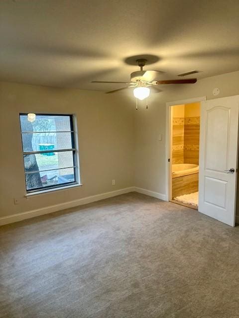 unfurnished bedroom with carpet floors, ceiling fan, and ensuite bath