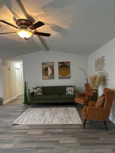 living room with wood-type flooring, vaulted ceiling with beams, and ceiling fan