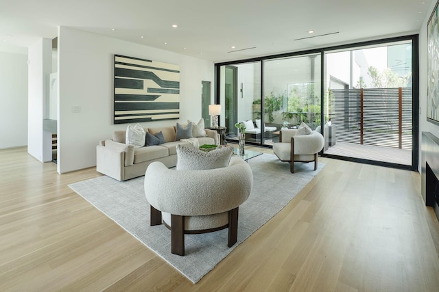 living room with floor to ceiling windows and light hardwood / wood-style floors