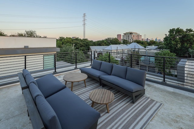 patio terrace at dusk with an outdoor living space and a balcony