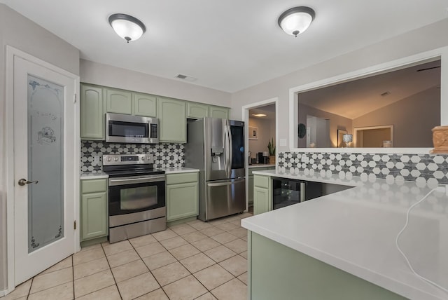 kitchen with stainless steel appliances, tasteful backsplash, wine cooler, green cabinetry, and light tile patterned floors