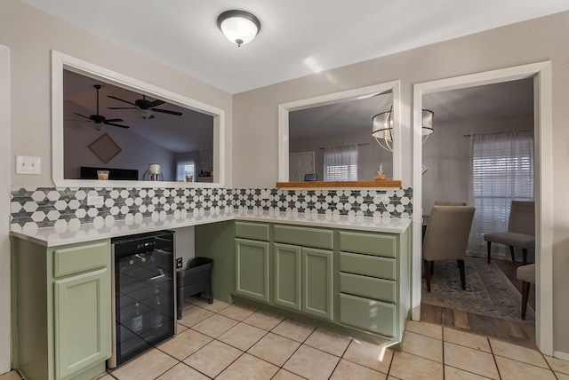 kitchen with light tile patterned floors, beverage cooler, and green cabinetry