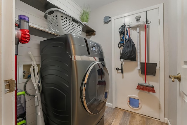 laundry area with hardwood / wood-style flooring and washing machine and dryer