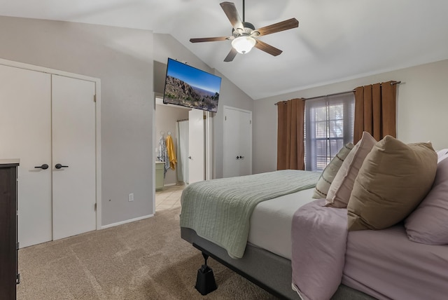 carpeted bedroom with vaulted ceiling, ceiling fan, and ensuite bathroom