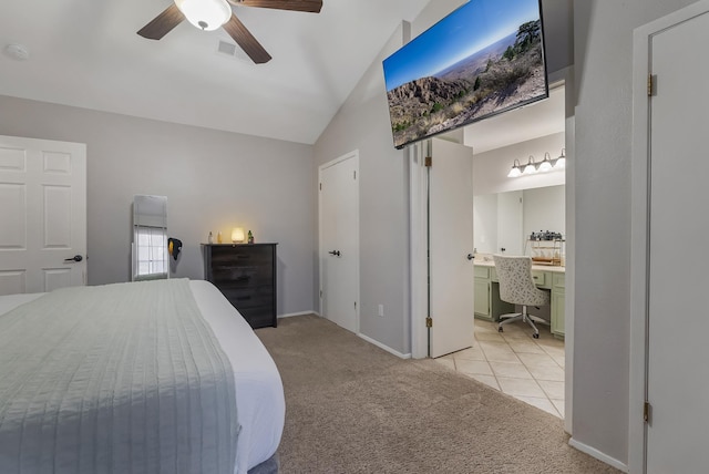 carpeted bedroom with vaulted ceiling, ceiling fan, ensuite bathroom, and built in desk