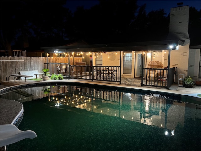 pool at twilight with a patio area